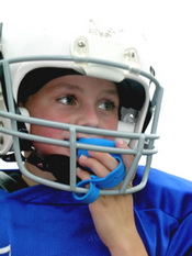 Child in football helmet with mouth guard - Pediatric and Cosmetic Dentists Keller, and Southlake TX - Donohue & Donohue, DDS